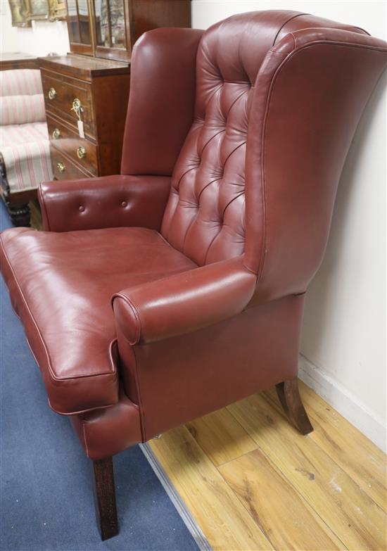 A leather button back wing armchair
